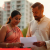 Indian couple discussing real estate investment with an agent in front of apartments